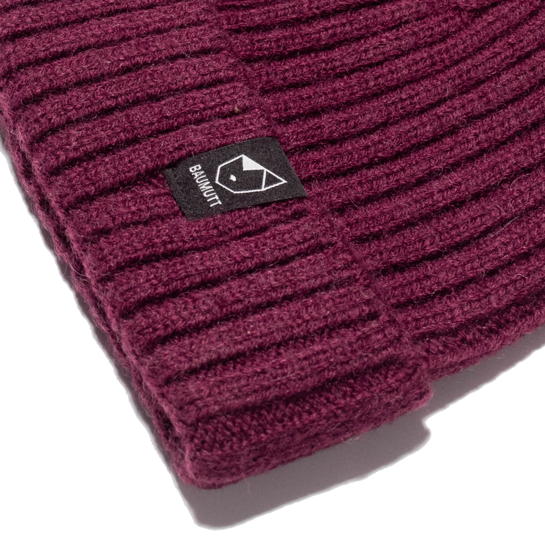 A Burgundy red BAUMUTT fisherman beanie hat with a snug fit, designed for men and women. side corner logo view