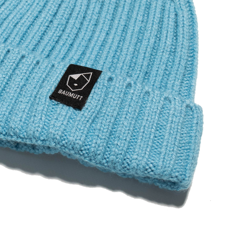 A aqua blue BAUMUTT fisherman beanie hat with a snug fit, designed for men and women. front corner logo view